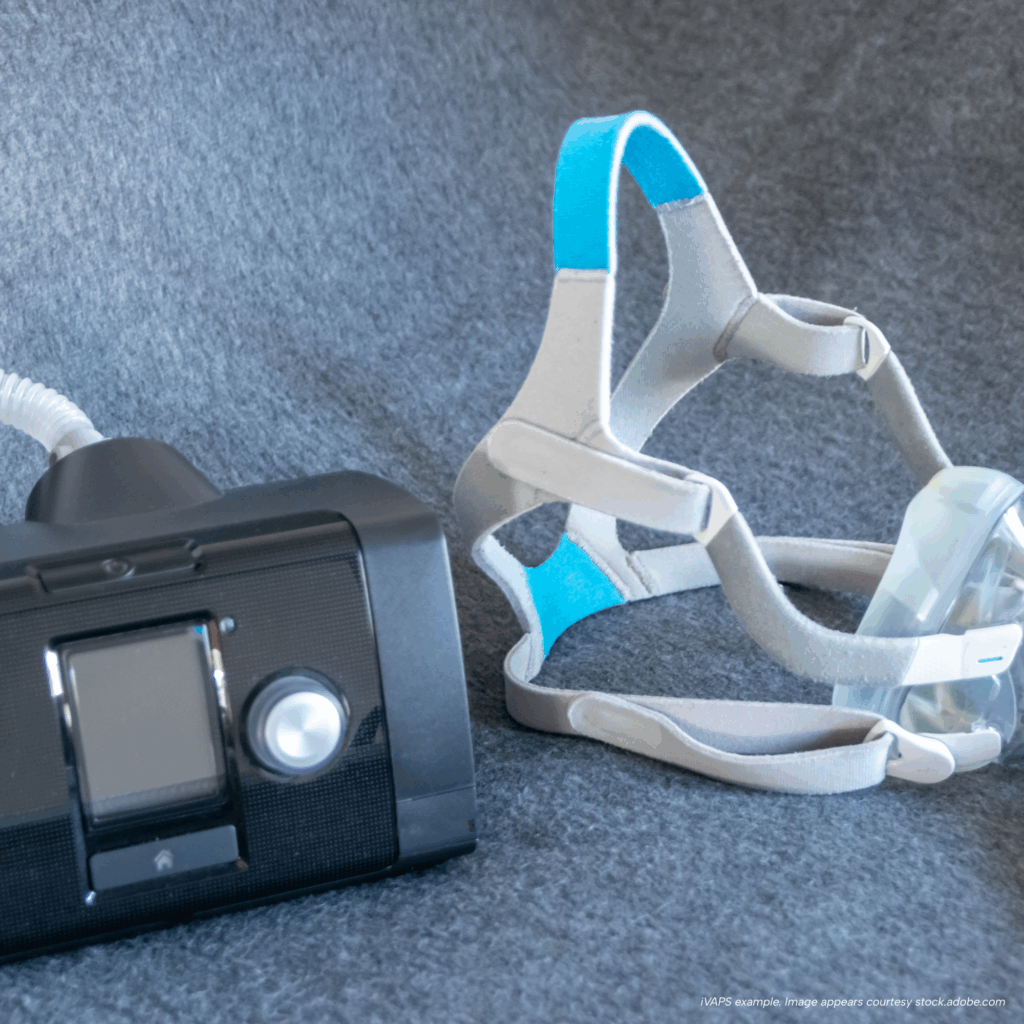 iVAPS ventilator with mask headgear and tubing shown on a soft gray surface.